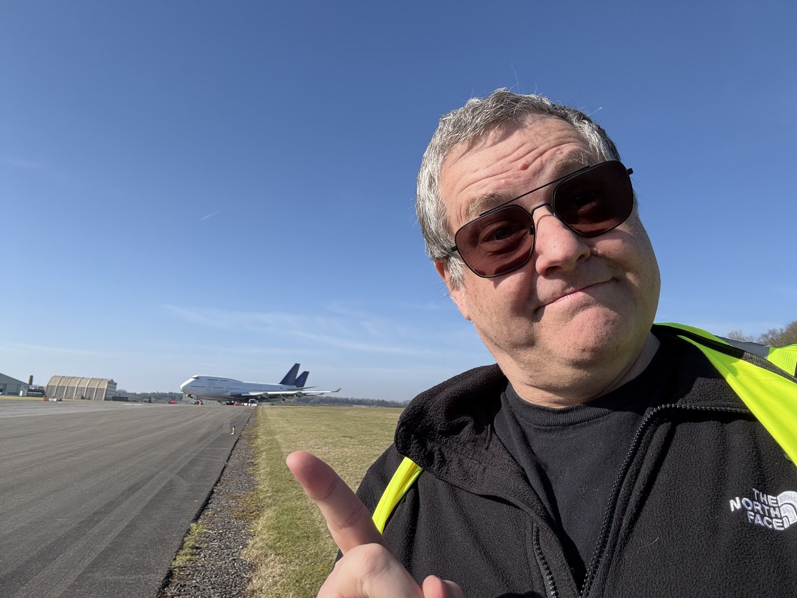 Wayne thumbs-up selfie, stored 747 behind, hi-vis on. Winter shot, second visit