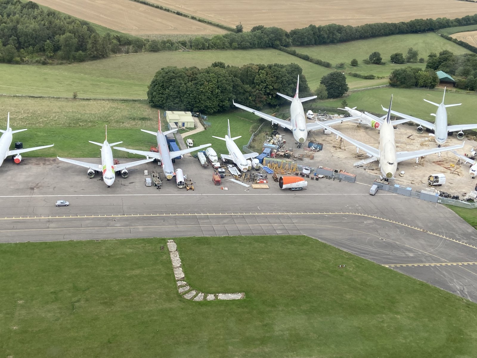 Aerial of airliners being broken up, nose sections and engines removed