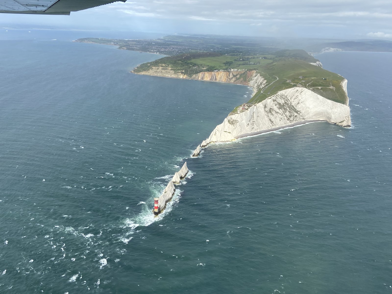 Aerial view of The Needles, lighthouse and Alum Bay coloured cliffs at the western tip of the Isle of Wight